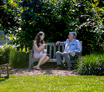 Two people talking on a bench. Links to Gifts from Retirement Plans