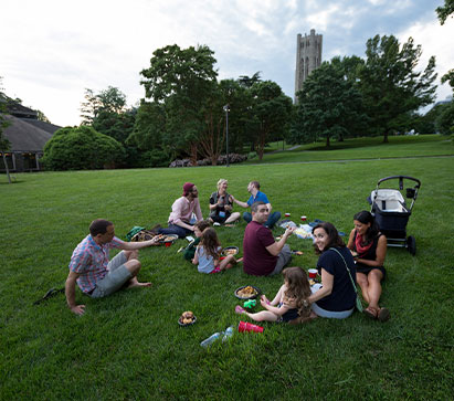 Photo of people sitting on the campus lawn. 