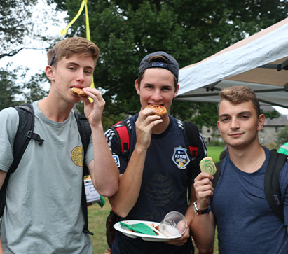 Photo of three students eating cookies. Links to Tangible Personal Property
