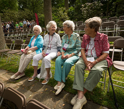 Photo of four women talking. 